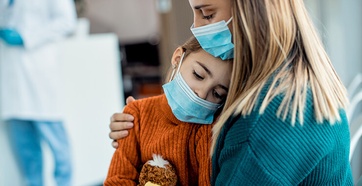 Child with the flu being held by mother