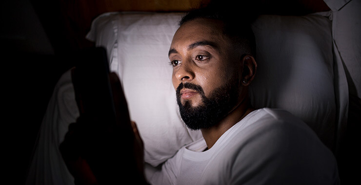 Man in bed with phone