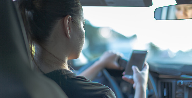 Young woman texting and driving