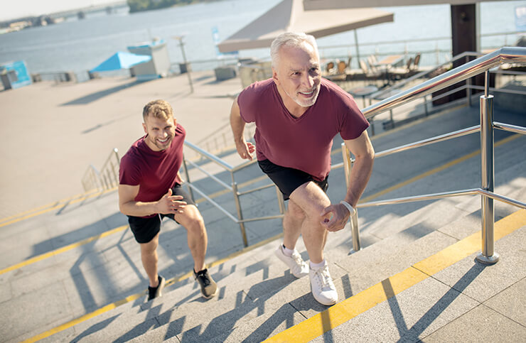 grey haired male young male running upstairs serious athletes or longevity-focused adults