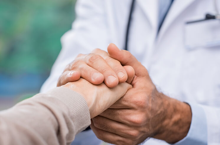 doctor and patient holding hands